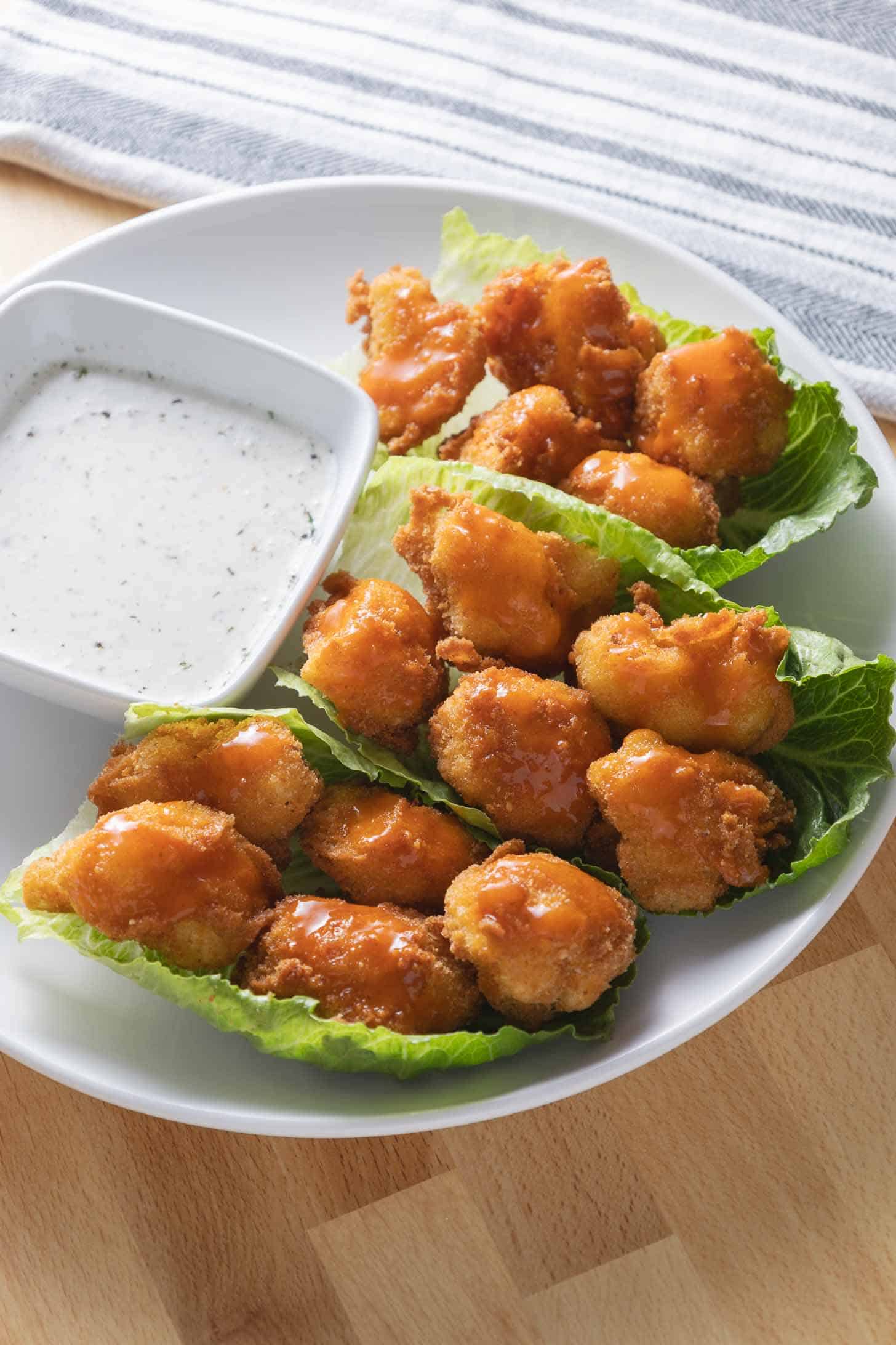 A plate of vegan buffalo cauliflower bites with a side of ranch