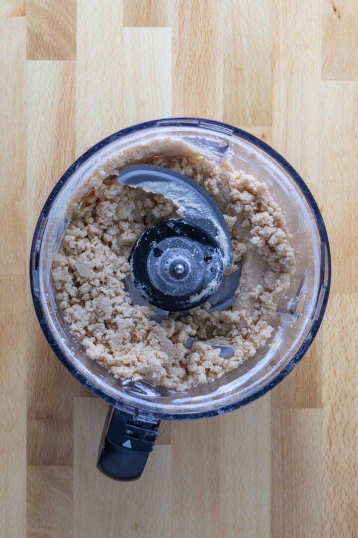 The dough coming together in the bowl of the food processor