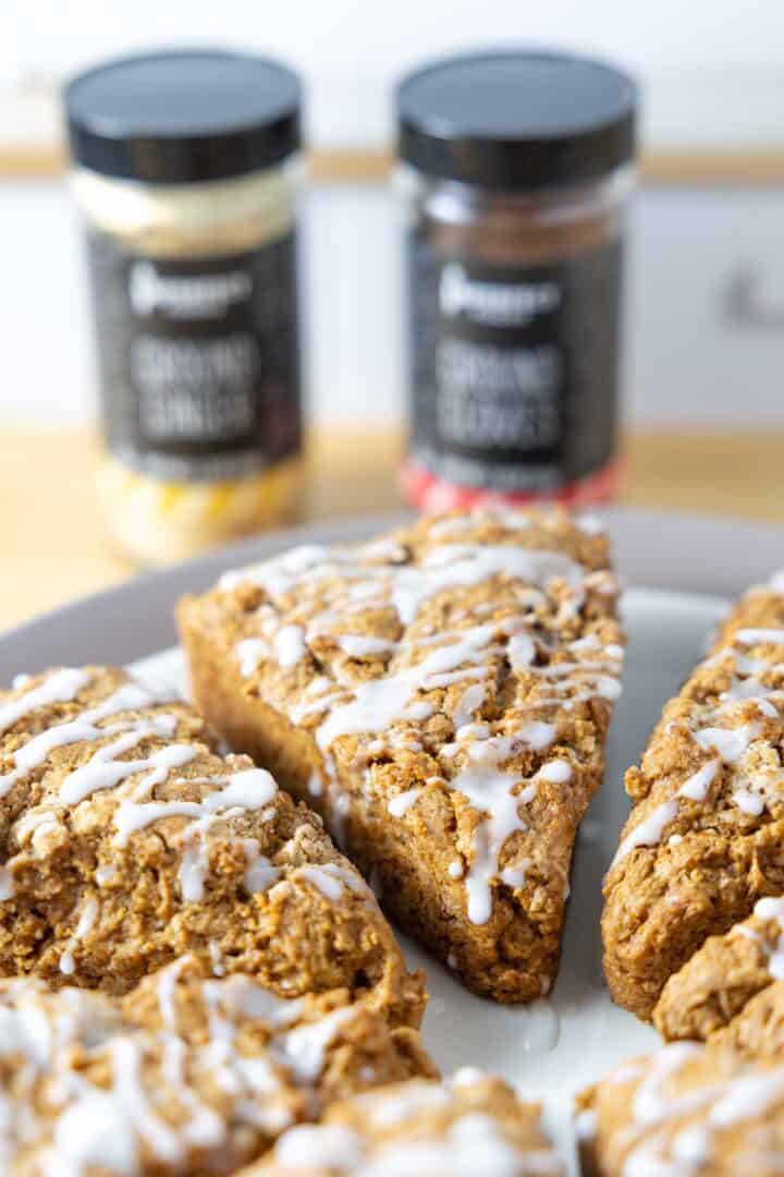 A plate of Vegan Gingerbread Scones with Vanilla Glaze