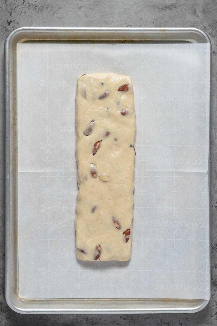 Forming the biscotti dough into an elongated bar on the parchment lined baking sheet.