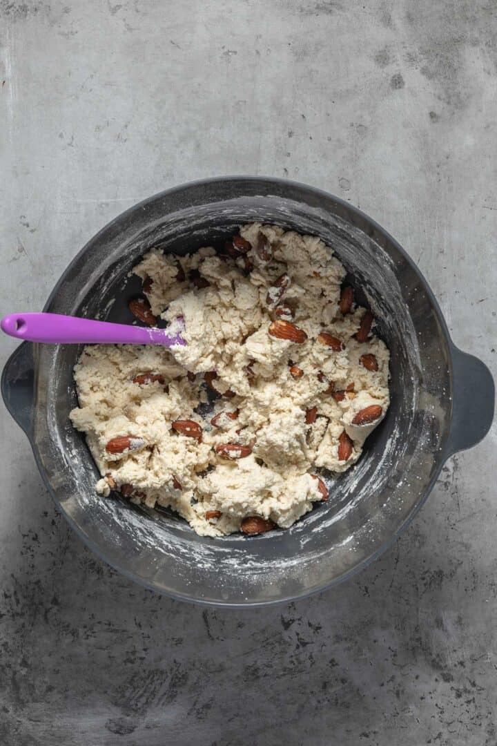 Folding in the remaining dry ingredients and the almonds into the biscotti recipe.