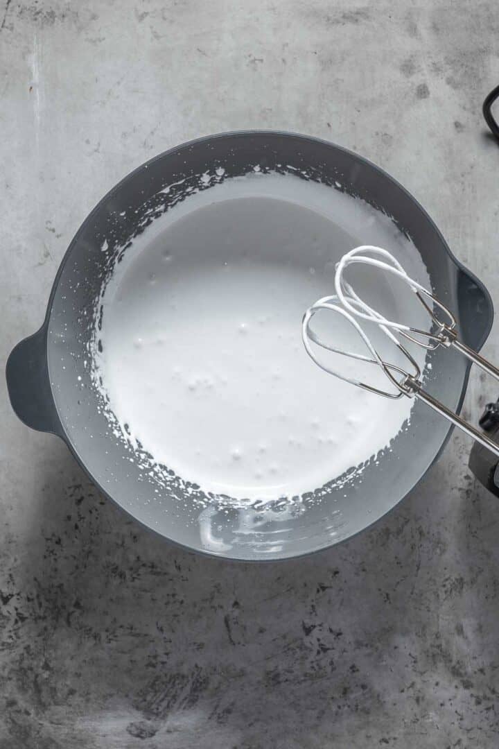 Whipping the sugar and the aquafaba together until it thickens enough to cling to the beaters. 